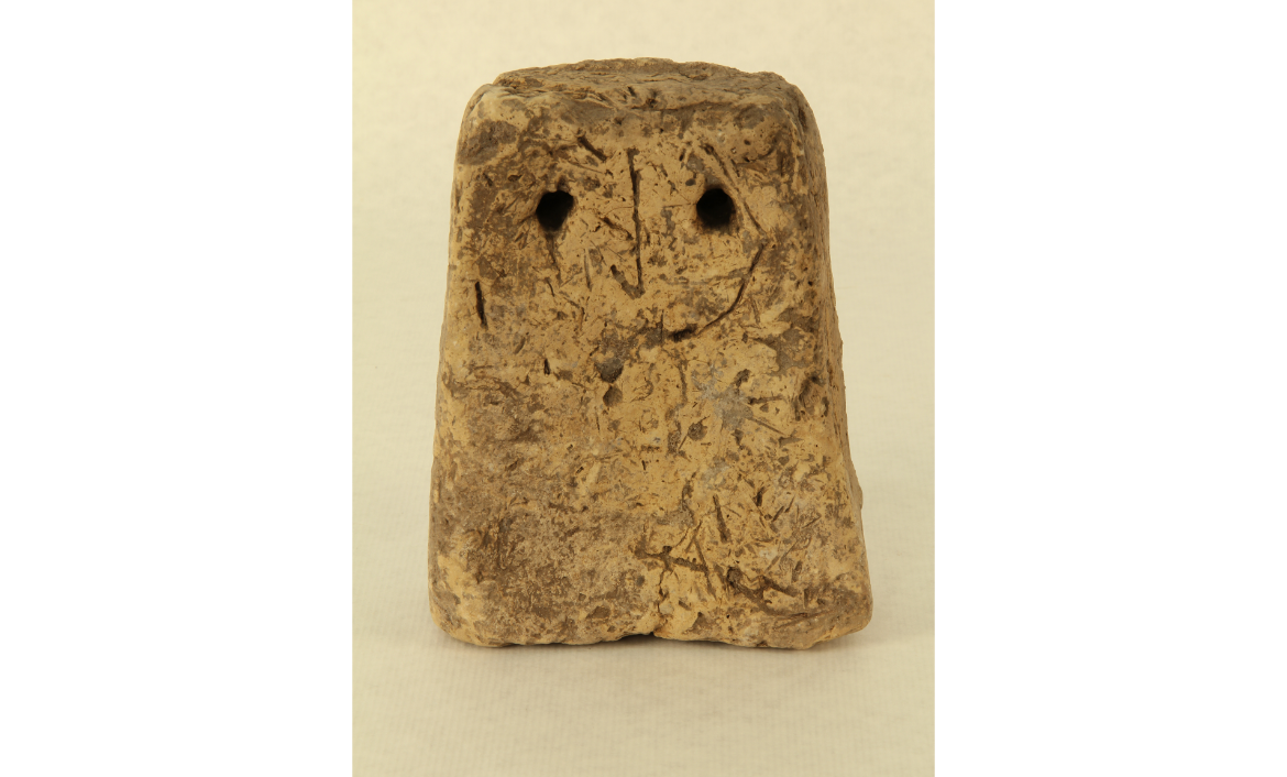 [MR 4898] – Pes de teler (pondus) de terracuita, amb els trets gravats d'una cara. Procedeix del jaciment  ibèric del Coll del Moro (Serra d'Almos, Tivissa). Segle III aE.
